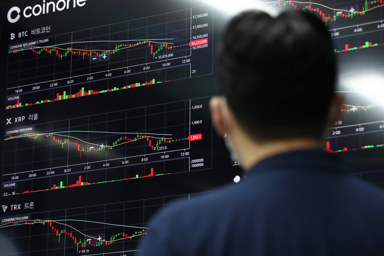 A man stares cryptocurrency prices on the display board at the Coinone customer center in Yongsan-gu, Seoul on Aug. 25. Coinone is one of major cryptocurrency operators in South Korea. (Yonhap)