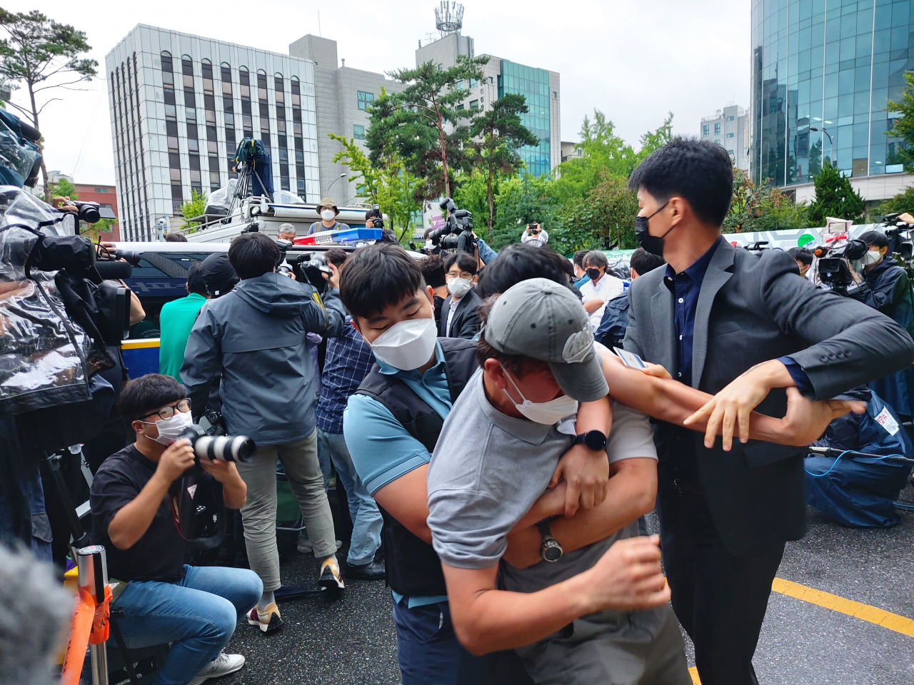 7일 오전 송파경찰서에서 여성 2명 살해 혐의로 이송되는 강윤성에게 한 남성(회색 모자 쓴 사람)이 달려들자 경찰이 제지하고 있다. 김희량 기자