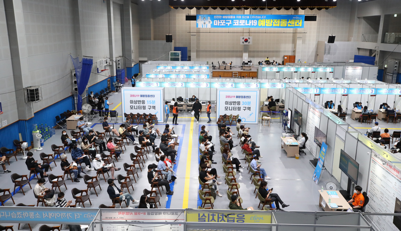 Photo shows people waiting at a vaccination clinic in Mapo, central Seoul, on Tuesday afternoon. (Yonhap)
