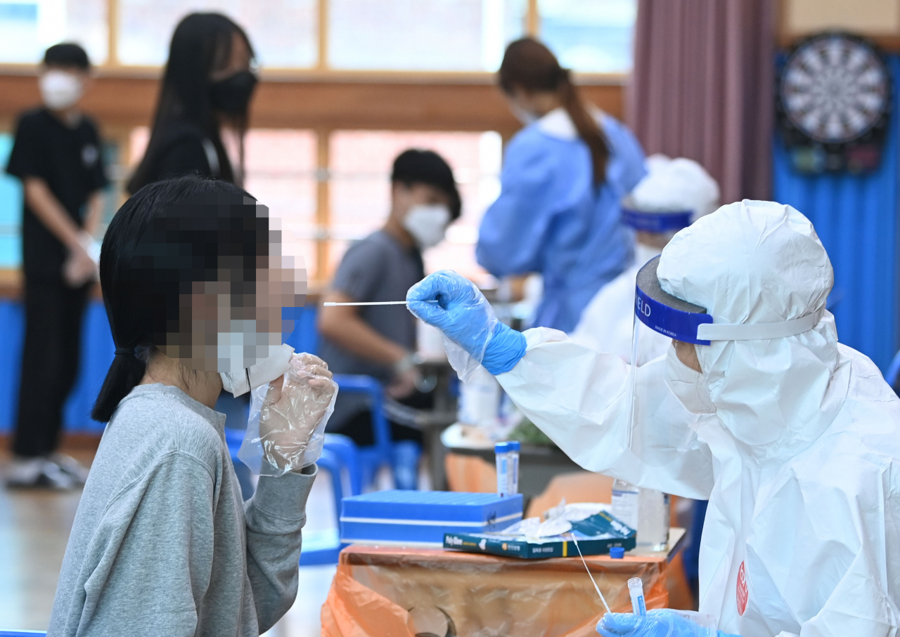 7일 오전 광주 북구의 한 중학교에서 총 13명의 코로나19 확진자가 발생, 이 학교 1~2학년 학생들이 전수검사를 받고 있다. [연합]