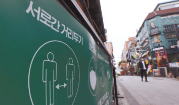 지난 6일 서울 용산구 이태원 세계음식거리 한 가게 입구에 사회적거리두기와 신종 코로나바이러스 감염증(코로나19) 방역 캠페인 내용이 적힌 배너가 세워져 있는 모습. [연합]