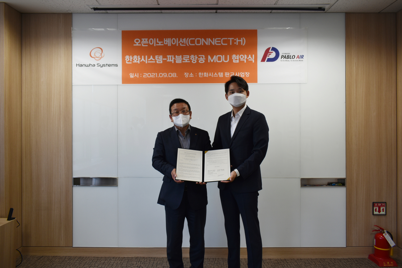 이수재 한화시스템 부사장·연구개발본부장(왼쪽)과 김영준 파블로항공 대표가 업무협악식에서 사진 촬영을 하고 있다. [한화시스템 제공]