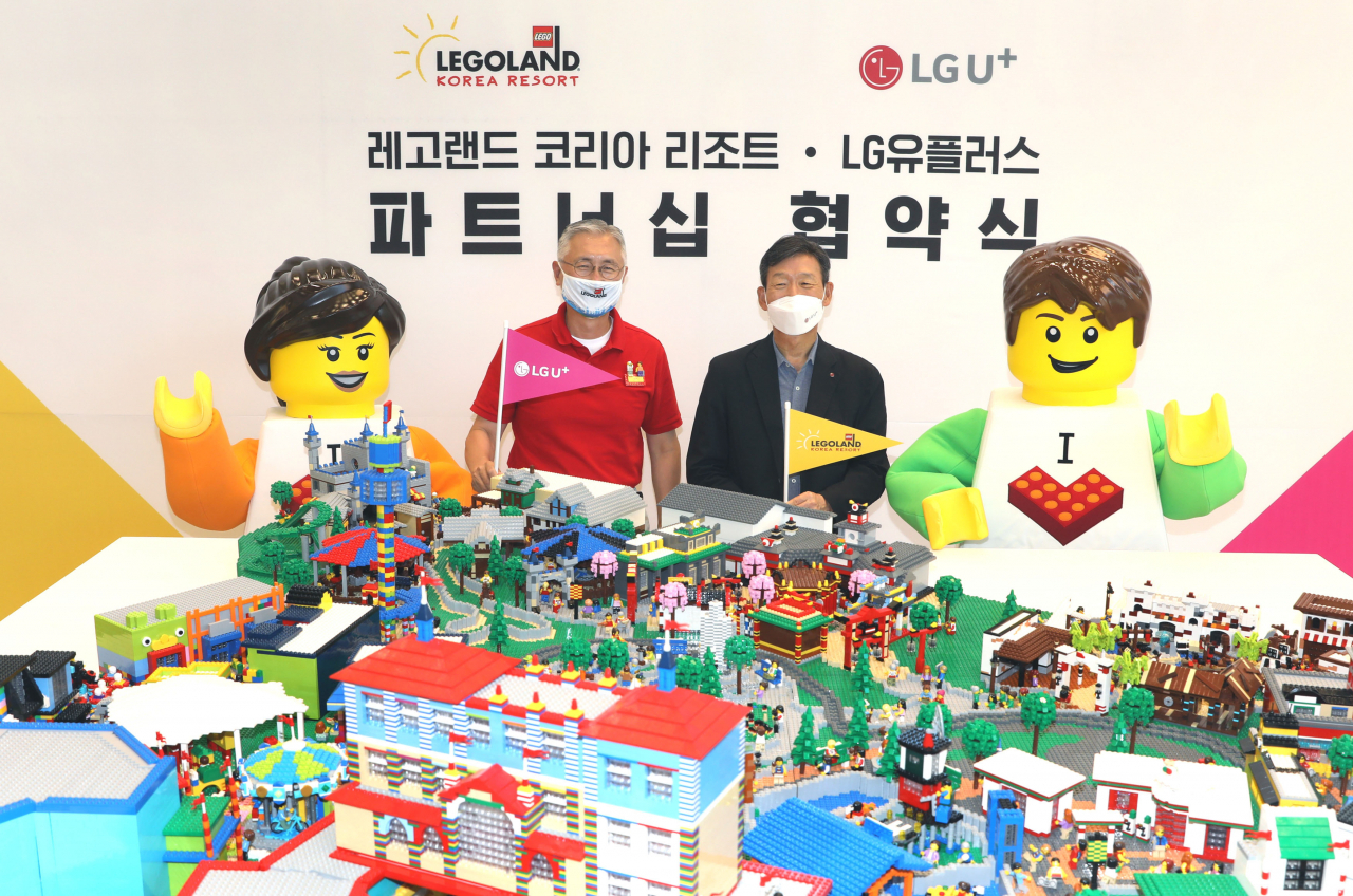 LG유플러스는 글로벌 테마파크 레코랜드 코리아와 독점 제휴를 체결했다고 9일 밝혔다. 황현식 LGU+사장(오른쪽)과 김영필 레고랜드 코리아 사장이 레고랜드 조감도 모형을 보며 기념 촬영을 하고 있다. [LG유플러스 제공]