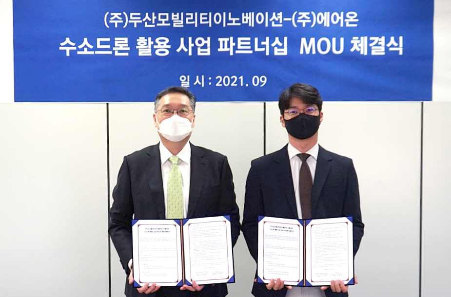 이두순 두산모빌리티이노베이션 이두순 대표와 ㈜에어온 구자균 대표가 지난 3일 업무협약(MOU)을 마치고 기념사진 촬영을 하고 있다. [두산 제공]