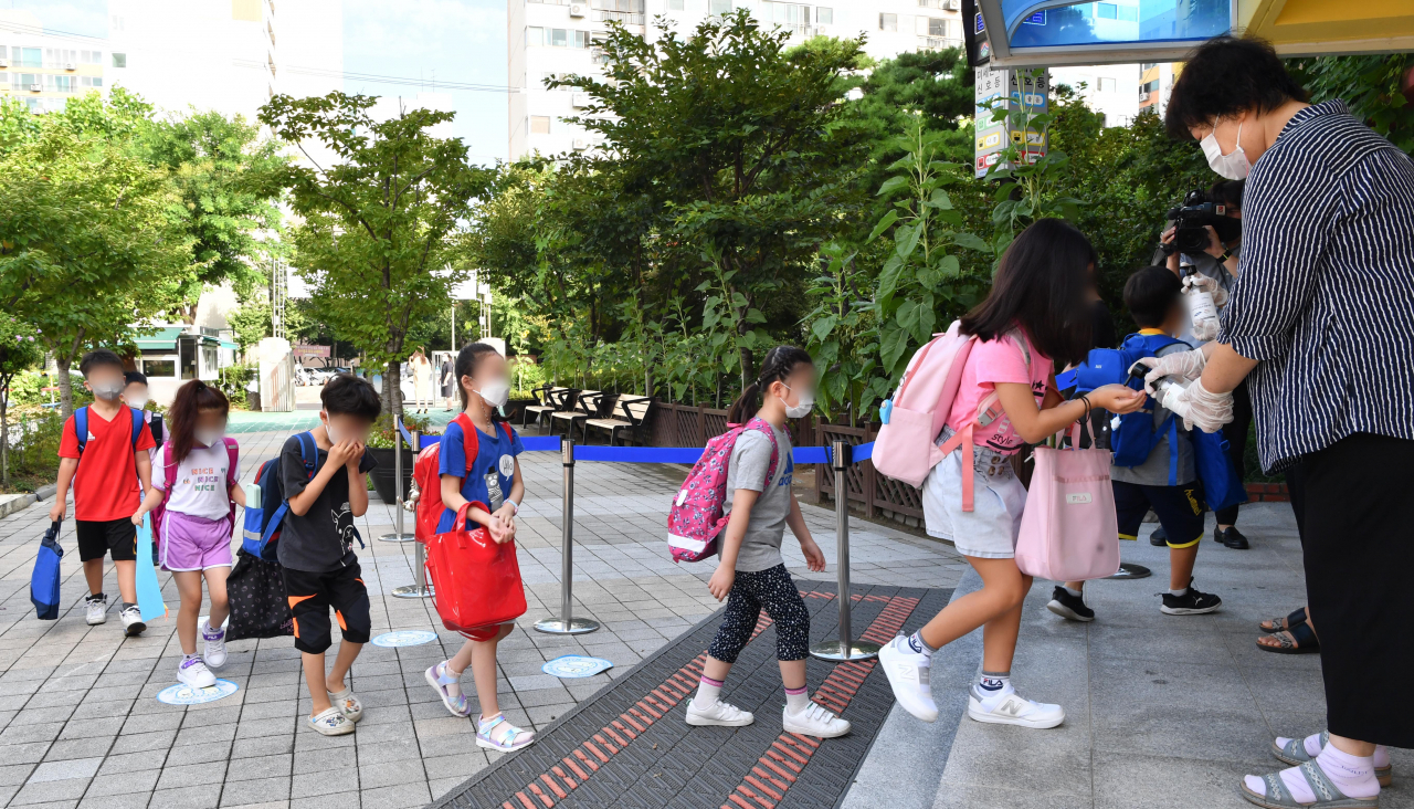 초등학교 1, 2학년의 2학기 등교수업이 시작된 지난 달 17일 서울 마포구 성원초에서 학생들이 등교하기 전 손 소독을 하고 있다. [연합]