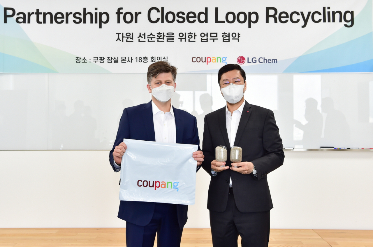 쿠팡 라이언 브라운 부사장(환경보건안전총괄·왼쪽)과 허성우 LG화학 부사장(석유화학글로벌사업총괄)이 9일 서울 잠실 쿠팡 본사에서 업무협약(MOU)을 체결한 뒤, 각각 쿠팡의 포장비닐과 LG화학의 재활용된 원료 펠렛을 들고 기념 촬영을 하고있다.[LG화학 제공]