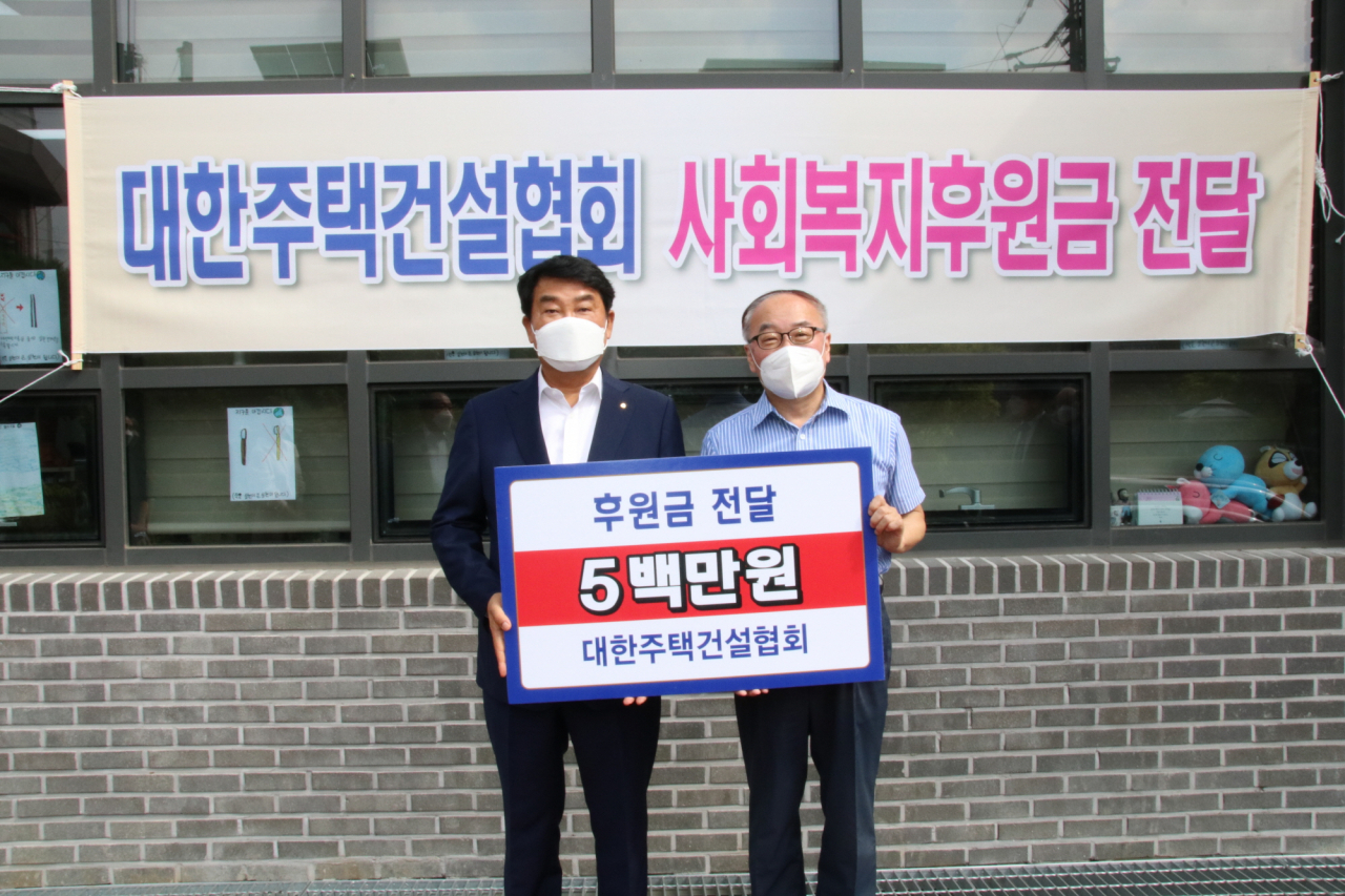 박재홍 대한주택건설협회 회장이 9일 서울 관악구 소재 동명아동복지센터 원장에게 후원금을 전달한 뒤 기념촬영을 하고 있다. [대한주택건설협회 제공]