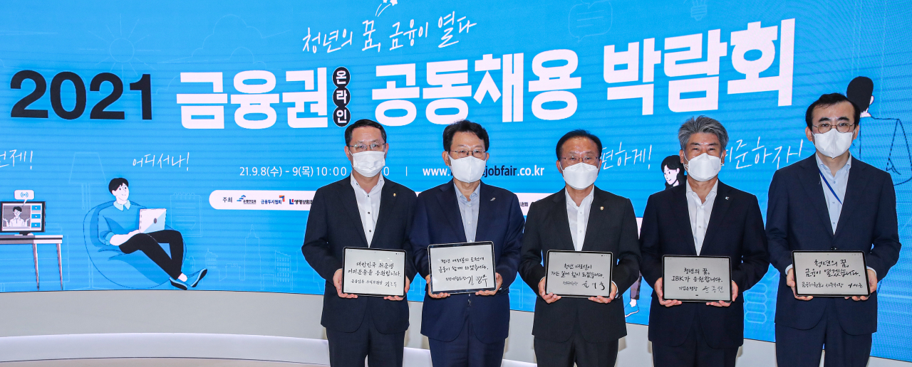 공기업과 공공기관에 ‘블라인드 채용’이 도입된 뒤 채용 과정의 공정성과 신뢰도가 높아지고 출신대학 수가 늘어나는 등 만족도가 높아진 것으로 나타났다. 사진은 지난 8일 오전 서울 중구 IBK 파이낸스 센터에서 개막한 2021년 금융권 온라인 공동채용 박람회 개막 행사에서 내빈들이 서명한 취업 성공을 위한 메시지가 담긴 태블릿 PC를 들고 기념 촬영하고 있는 모습. 왼쪽부터 김근익 금융감독원 수석부원장, 김광수 은행연합회장, 윤재옥 국회 정무위원회 위원장, 윤종원 기업은행장, 이세훈 금융위원회 사무처장.[연합]