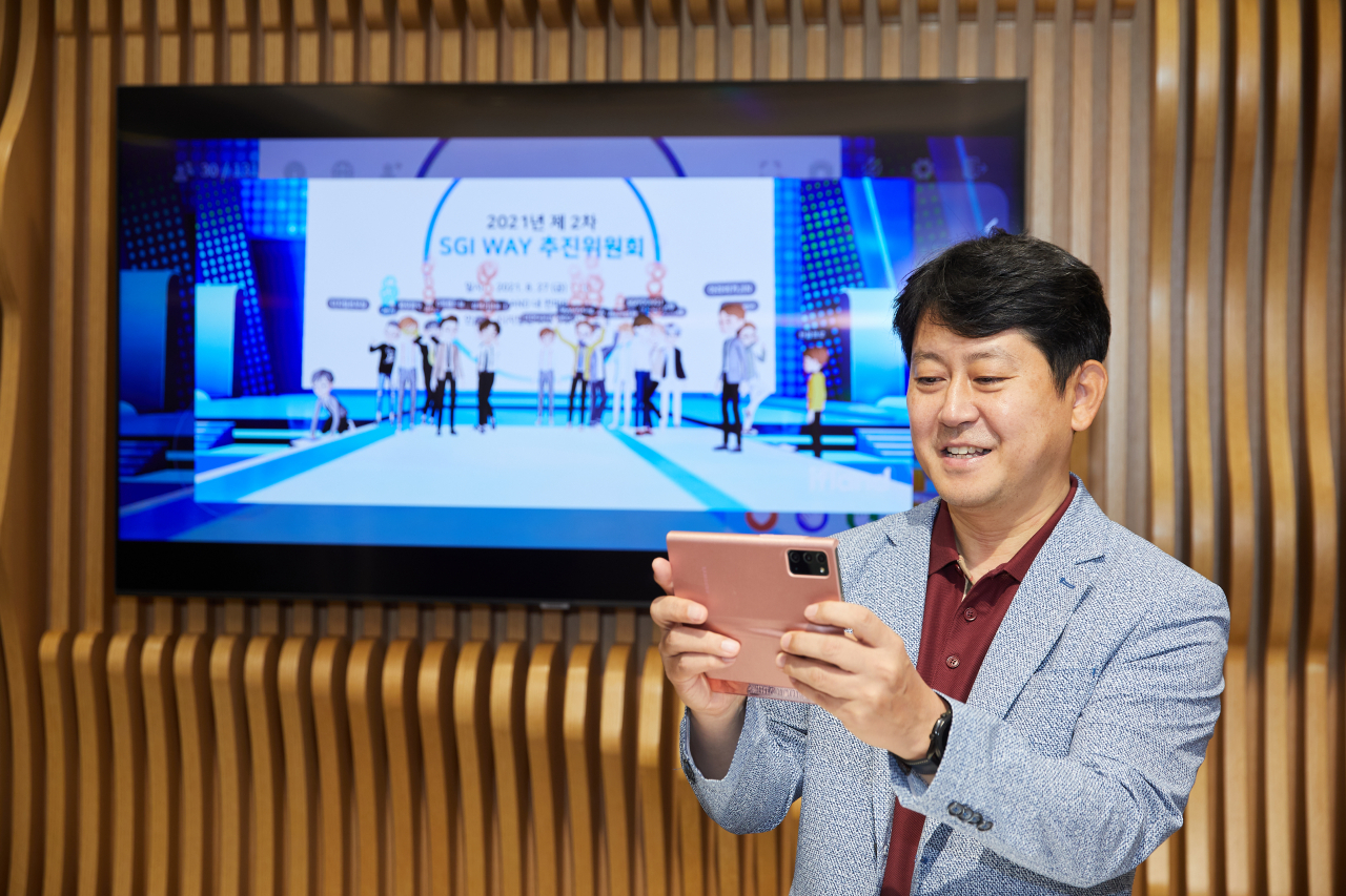 유광열 서울보증보험 대표이사가 지난달 27일 휴대전화를 이용해 디지털 전략과제 회의에 참석하고 있다.