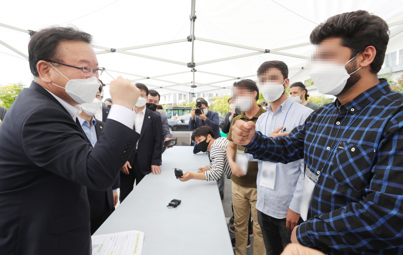 김부겸 국무총리(왼쪽)가 10일 오전 아프간 특별기여자 임시생활 시설인 충북 진천 국가공무원 인재개발원을 방문해 아프간 대표자들과 면담을 마친 뒤 힘내라며 주먹을 들어보이고 있다. [연합]