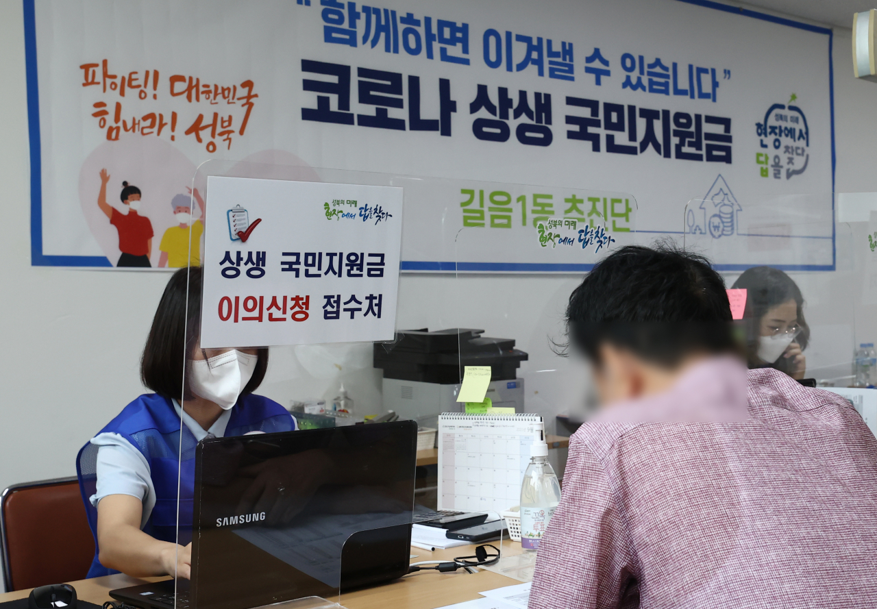 코로나 상생 국민지원금 현장 접수를 사흘 앞둔 10일 오전 서울 성북구 길음1동 주민센터에 한 시민이 국민지원금 관련 이의신청을 하고 있다. 연합뉴스