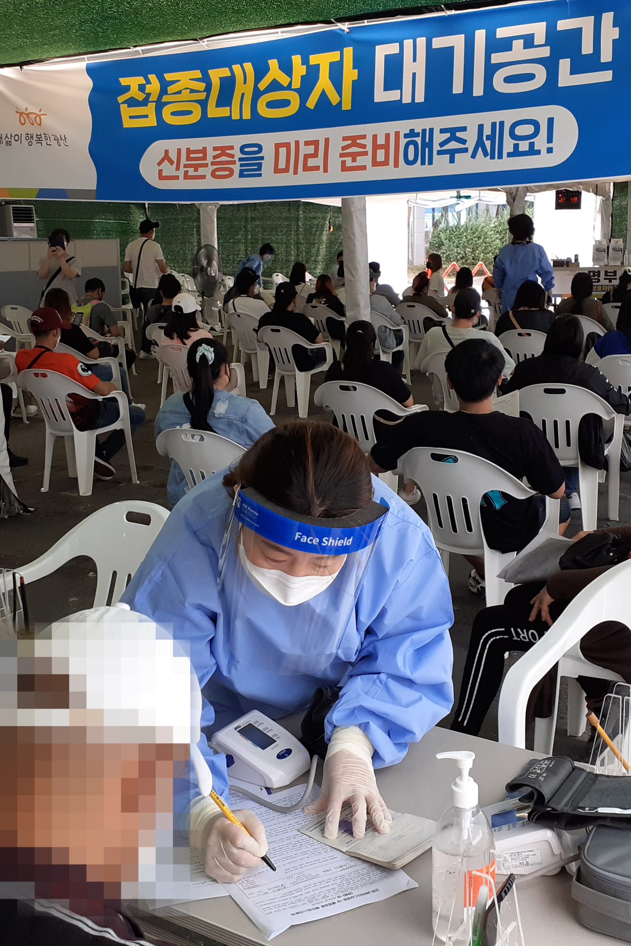 12일 광주 광산구 광주보훈병원에 마련된 신종 코로나바이러스 감염증(코로나19) 예방접종센터에서 외국인 주민이 백신 접종 절차를 안내받고 있다. 연합뉴스