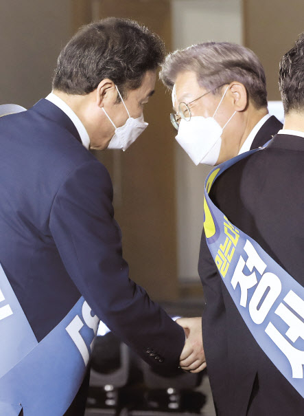 12일 오후 강원 원주시 오크밸리리조트 컨벤션센터에서 열린 더불어민주당 강원권역 순회경선 합동연설회에서 이낙연, 이재명 후보가 인사하고 있다. [연합]