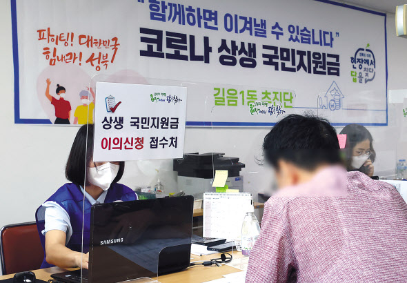코로나 상생 국민지원금 현장 접수를 사흘 앞둔 10일 오전 서울 성북구 길음1동 주민센터에 한 시민이 국민지원금 관련 이의신청을 하고 있다. [연합]