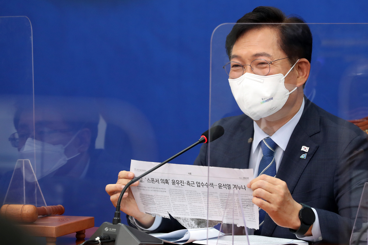 더불어민주당 송영길 대표가 13일 오전 국회에서 열린 최고위원회의에서 일간지 기사를 들어보이고 있다. [연합]