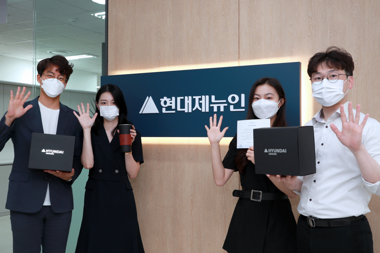 경기 성남시에 위치한 현대제뉴인 분당 사무소에서 웰컴 키트를 증정 받은 직원들이 환하게 웃고 있다. [현대중공업그룹 제공]