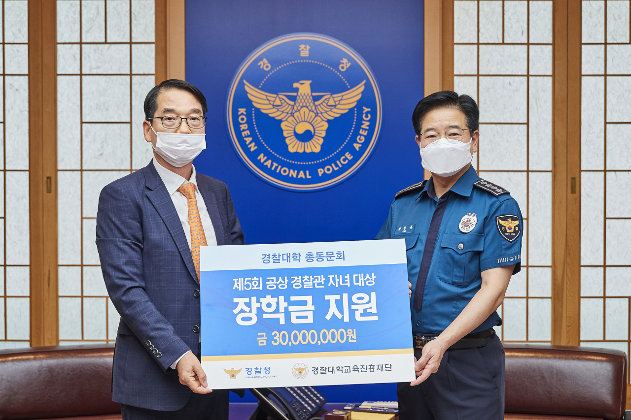 김창룡 경찰청장(오른쪽)이 13일 오후 경찰대학 총동문회가 공상경찰관 자녀에게 장학금을 전달하는 행사에 참여해 기념사진을 촬영하고 있다. [경찰청 제공]