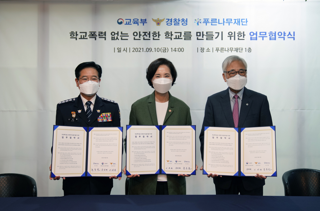 유은혜 사회부총리 겸 교육부 장관(가운데)이 지난 10일 오후 서울 푸른나무재단에서 열린 '학교폭력 없는 안전한 학교를 만들기 위한 업무 협약식'에 참석해 김창룡 경찰청장(가운데), 문용린 푸른나무재단 이사장과 기념 촬영을 하고 있다. [교육부 제공·연합]