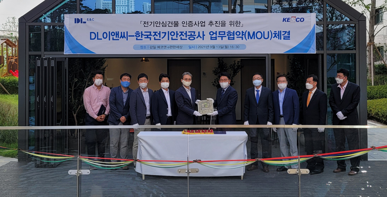 경기도 하남 감일 에코앤 e편한세상 현장에서 권수영 DL이앤씨 주택사업본부장(사진 왼쪽 다섯번째)과 김권중 한국전기안전공사 기술이사(왼쪽 여섯번째)가 전기 안심건물 인증 현판을 주고 받고 있다.