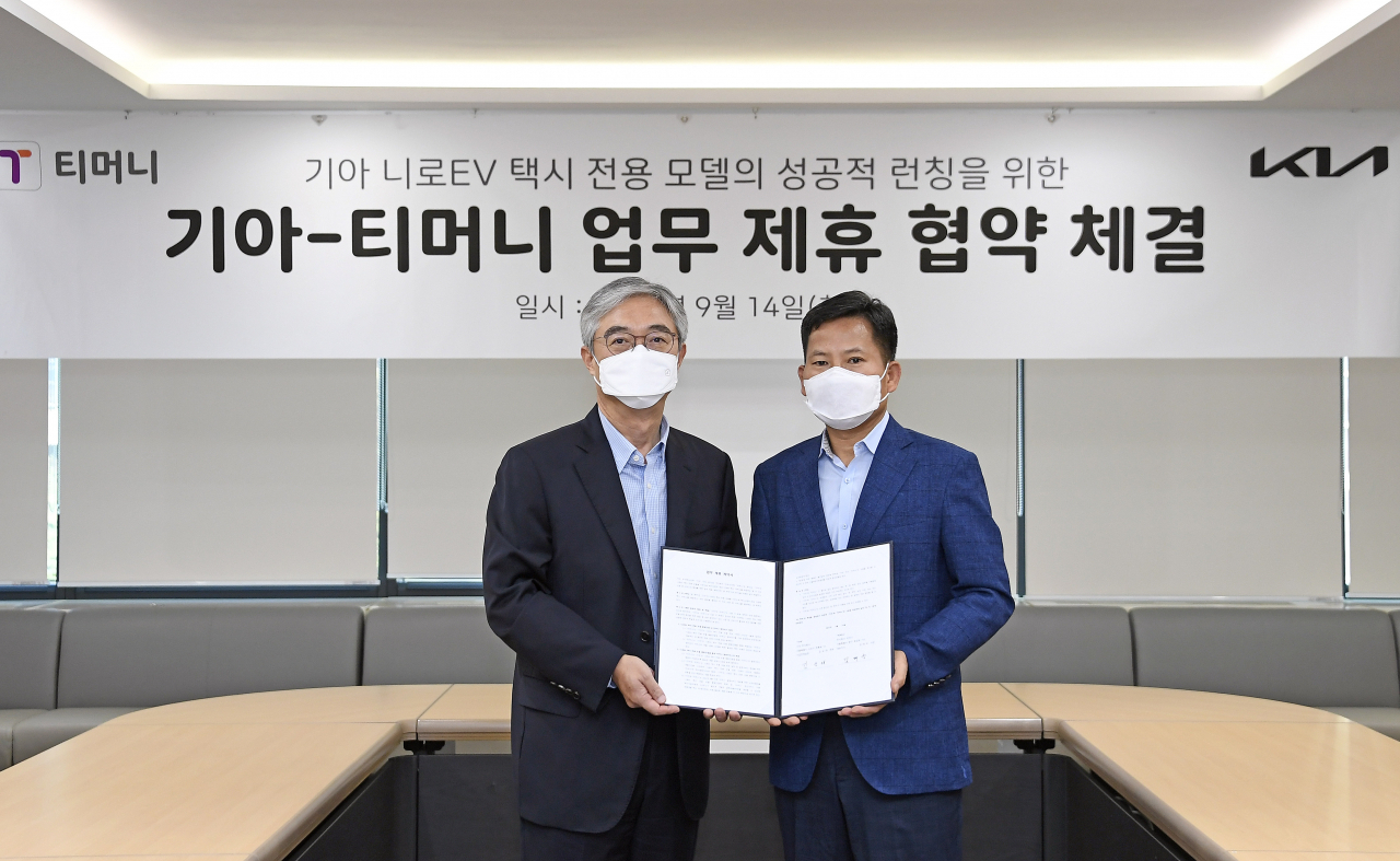 서울역 서울시티타워에 있는 티머니 사옥에서 기아 기업전략실장 김상대 전무(오른쪽)와 티머니 대표이사 김태극 사장이 업무 제휴협약 체결 후 기념사진을 촬영하고 있다. [기아 제공]