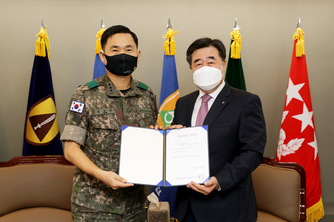 김형 대우건설 대표이사(오른쪽)와 김도균 수도방위사령관이 지난 14일 수도방위사령부 본청에서 진행된 위문금 전달식에서 기념촬영을 하고 있다. [대우건설 제공]