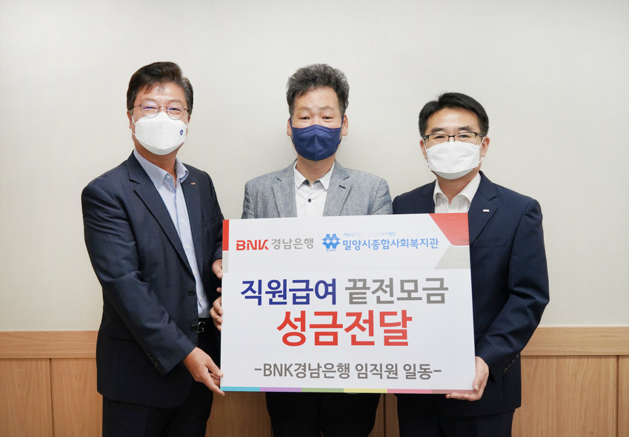 BNK경남은행 김종학 팀장과 밀양지점 김태곤 지점장이 밀양시종합사회복지관 한영섭 관장에게 ‘백합나눔회성금 기탁 증서’를 전달하고 있다.