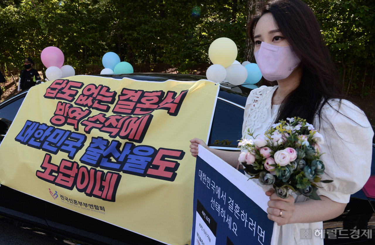 다음달 결혼을 앞둔 한 예비신부가 15일 오전 서울 영등포구 여의도동 KBS 앞 도로에서 결혼식장 방역지침 개선을 촉구하는 ‘웨딩카 주차시위’를 하고 있다. 박해묵 기자