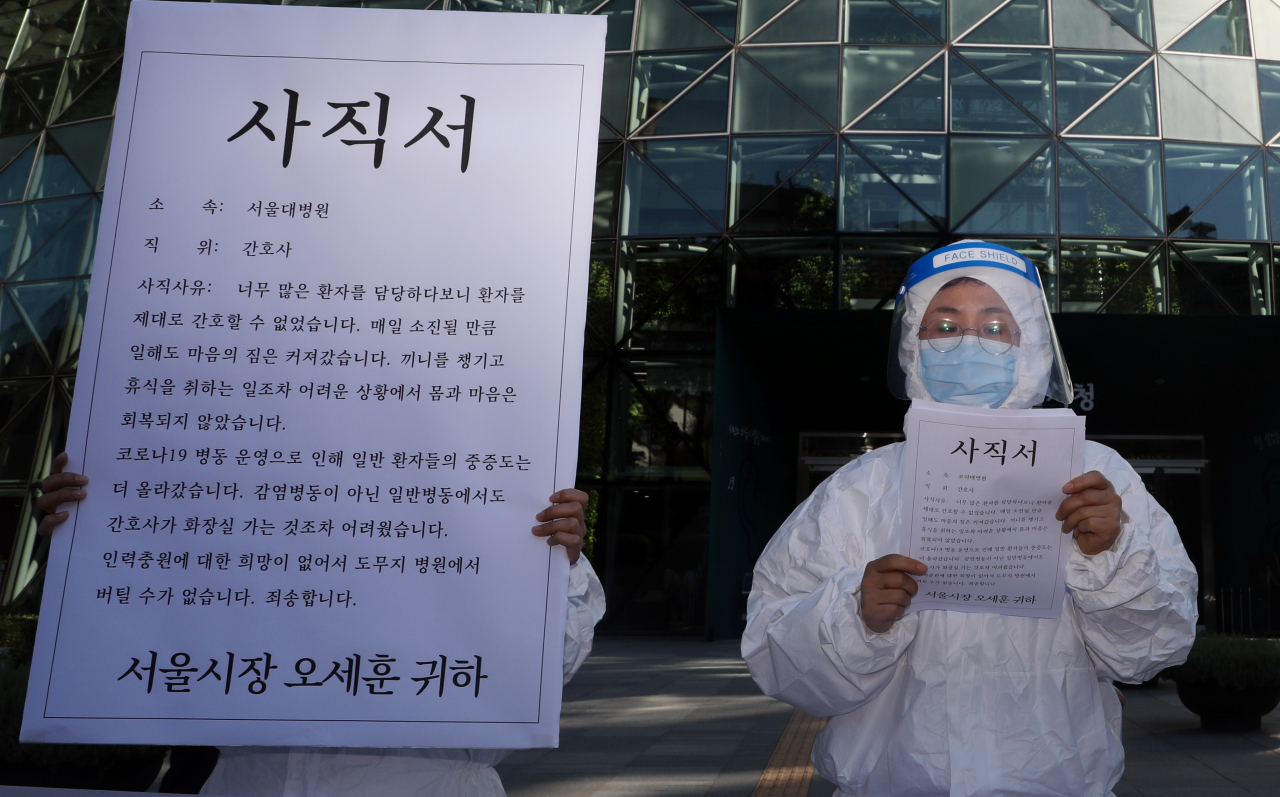 민주노총 의료연대본부가 15일 서울시청 앞에서 코로나19 간호인력 기준 발표를 촉구하는 기자회견을 하고 있다. [연합]