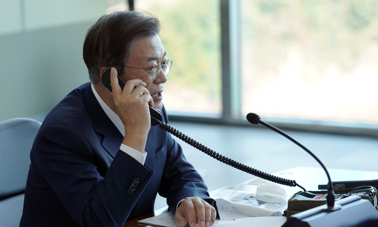 President Moon Jae-in speaks with the captain of the Navy's Dosan Ahn Chang-ho submarine while inspecting the underwater test-launch of the nation's indigenous submarine-launched ballistic missile on Wednesday. (Cheong Wa Dae)