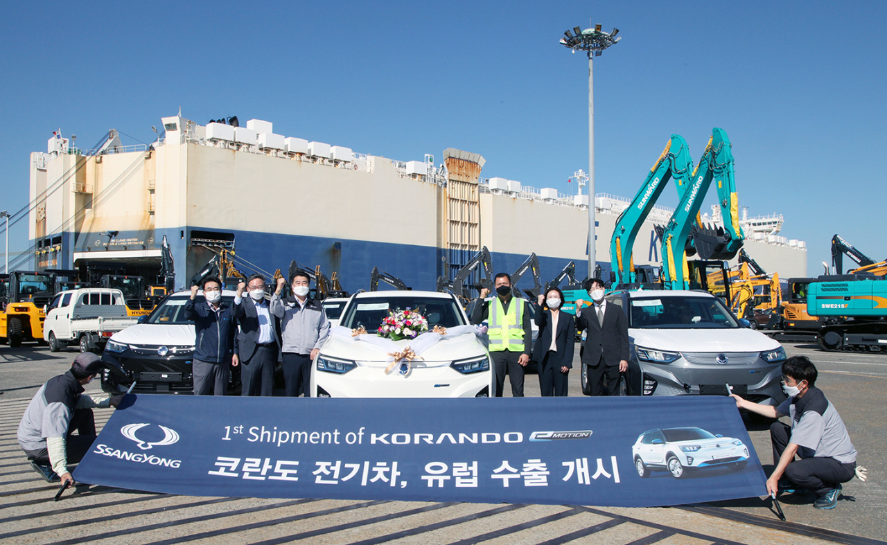 쌍용자동차가 첫 전기차인 코란도 이모션(Korando e-Motion) 수출 선적 기념식을 열고 글로벌 시장 공략 강화에 나섰다. 평택 국제자동차부두 이홍규 대표, 공항 항만 운송본부 평택 국제 자동차부두 하태유 지부장, 유코카 케리어스 정찬옥 이사 등 관계자들이 선적을 축하하며 파이팅을 외치고 있다. [쌍용차 제공]