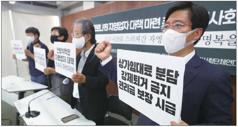 16일 서울 종로구 참여연대에서 열린 코로나19 중소상인·자영업자 대책 마련 촉구 시민사회단체 기자회견에서 참석자들이 집합금지·제한·피해업종 추가 긴급재정지원, 상가임대료 대책 마련, 강제퇴거 금지를 촉구하며 구호를 외치고 있다. [연합]