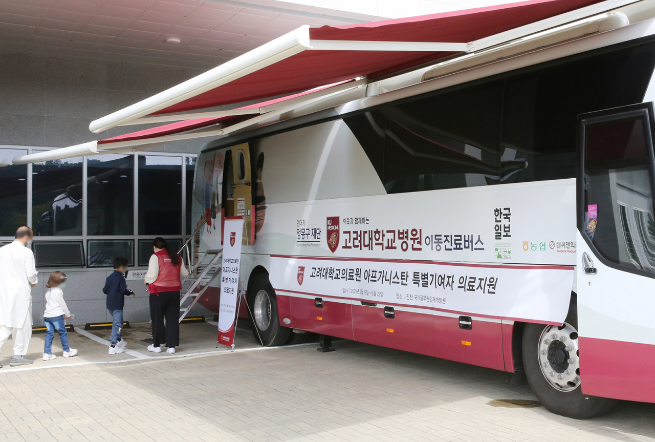 [사진4] 고려대의료원 의료버스에 아프간인들이 검진을 위해 오르고 있다.