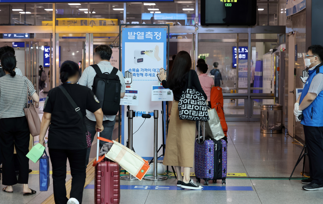 추석 연휴가 이틀 앞으로 다가온 16일 오후 서울 용산역에서 여행객들이 열차 탑승 전 체온을 측정하고 있다. 코로나19 신규 확진자의 80%가 수도권에서 이틀째 발생하면서 추석 귀성을 통한 급속한 확산에 대해 보건 당국의 방역에 대한 고민이 증가하고 있다. 연합뉴스