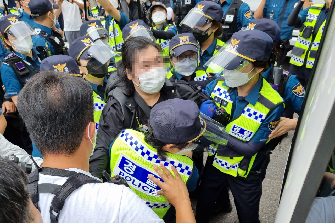 17일 오전 경찰이 정부서울청사 별관에 무단 진입해 시위를 벌인 ‘체제전환을 위한 청년시국회의’ 회원들을 현행범으로 체포해 연행하고 있다. [연합]