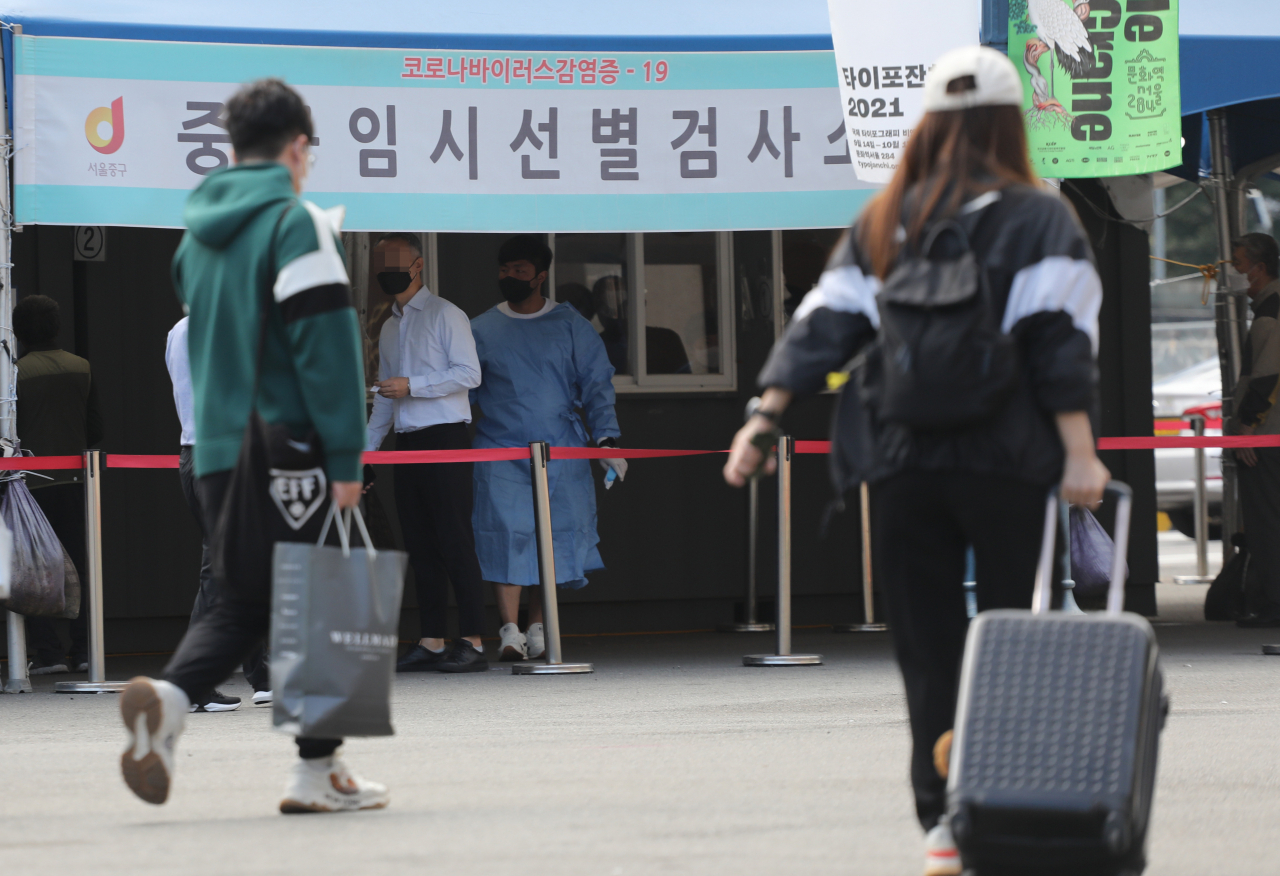 추석연휴를 앞둔 17일 서울역 선별검사소 앞을 시민들이 지나가고 있다. [연합]