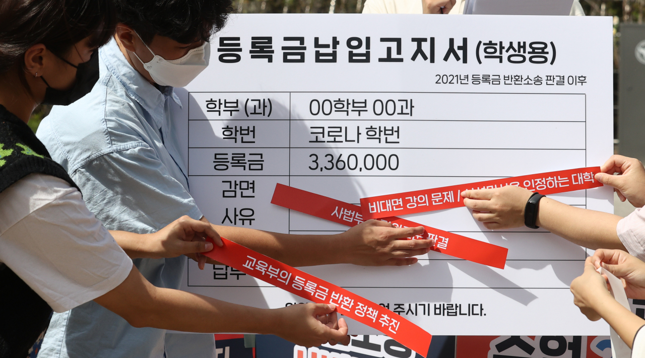 16일 오후 서울 서초구 서울중앙지법 앞에서 전국대학학생회네트워크·2021등록금반환운동본부 회원들이 사법부에 비대면 수업 대학 등록금 반환 판결을 촉구하며 퍼포먼스를 하고 있다. [연합]