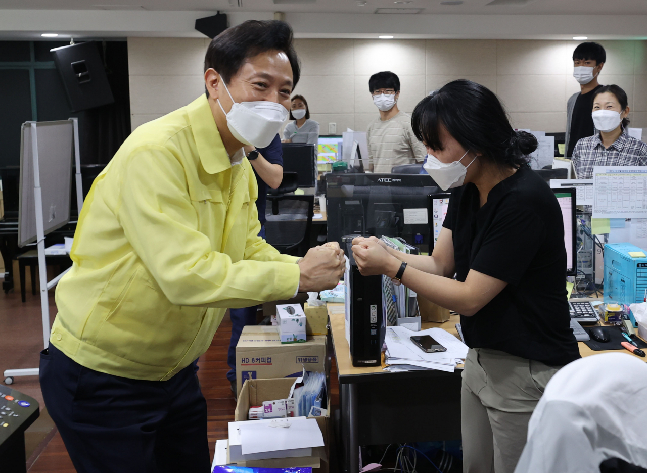 오세훈 서울시장이 지난 18일 오전 서울 중구 국립중앙의료원 코로나19 공동대응상황실을 찾아 추석연휴 코로나19 대응사항을 점검하며 직원들과 인사를 나누는 모습. [연합]