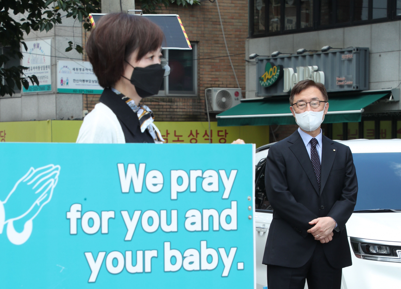 국민의힘 대권주자인 최재형 전 감사원장이 22일 서울 마포구 경의선숲길 인근에서 열린 태아생명보호를 위한 40일 기도캠페인에서 부인 이소연 씨가 낙태 반대 릴레이 1인 시위하는 모습을 지켜보고 있다. [연합]