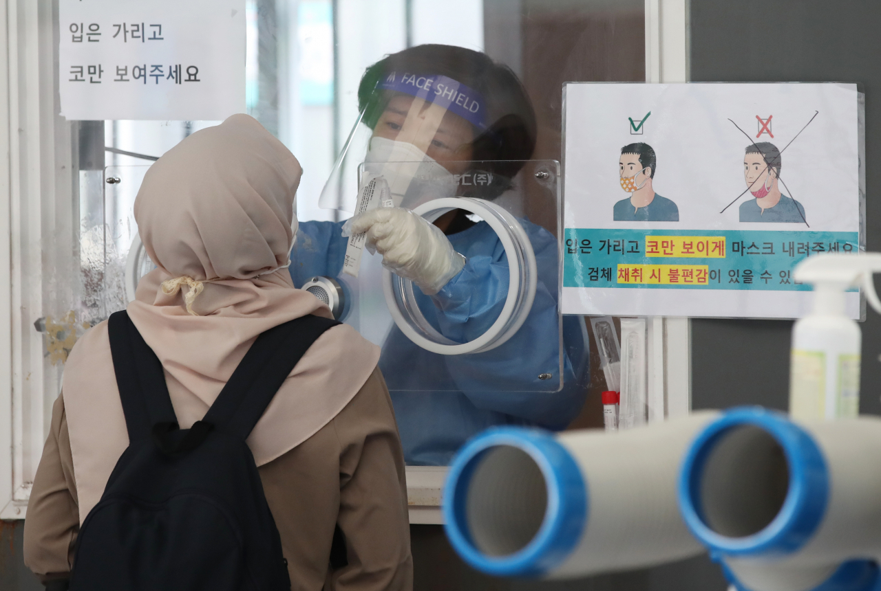 22일 오후 서울 중구 서울역 광장 임시 선별검사소에서 히잡을 쓴 외국인들이 코로나19 검사를 받고 있다. [연합]