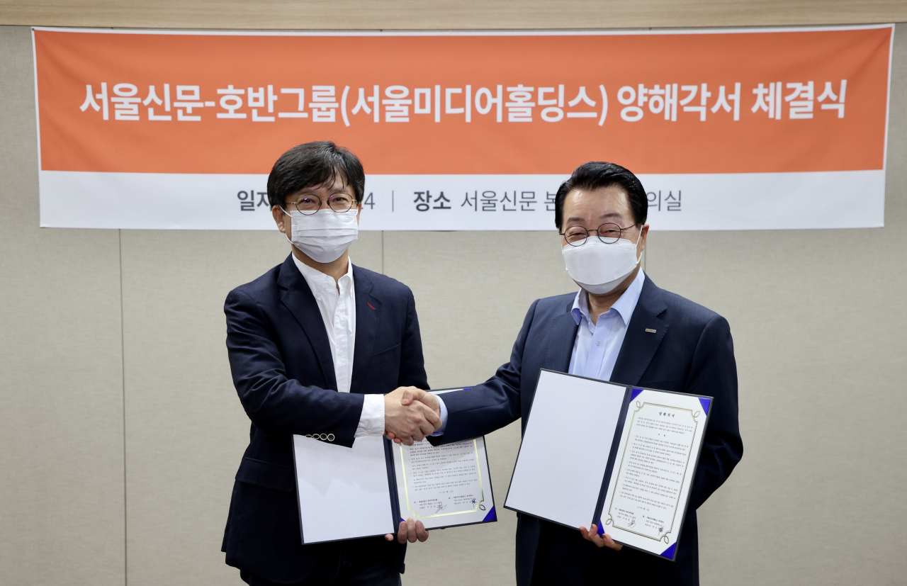 호반그룹과 서울신문 우리사주조합이 주식매매를 위한 양해각서를 체결했다. 이호정 서울신문 우리사주조합장(왼쪽)과 최승남 호반그룹 수석부회장이 24일 서울신문에서 양해각서를 체결한 뒤 악수를 하고 있다. [호반그룹 제공]