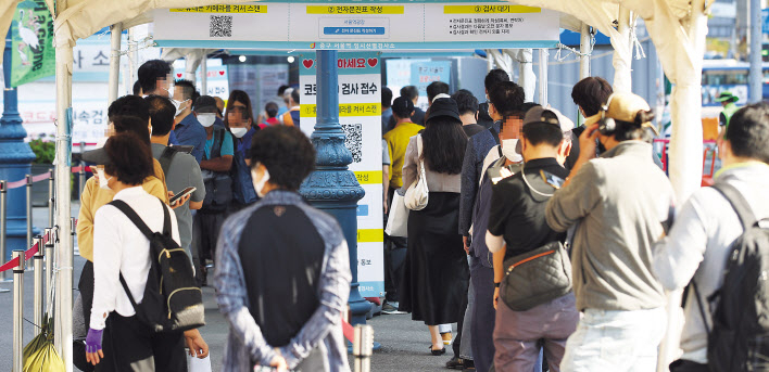 추석 연휴가 끝나자마자 코로나19 신규 확진자 수가 폭증하면서 최다치를 기록한 24일 오전 서울역 광장에 마련된 중구임시선별검사소에서 시민들이 검사를 받기 위해 기다리고 있다. [연합]