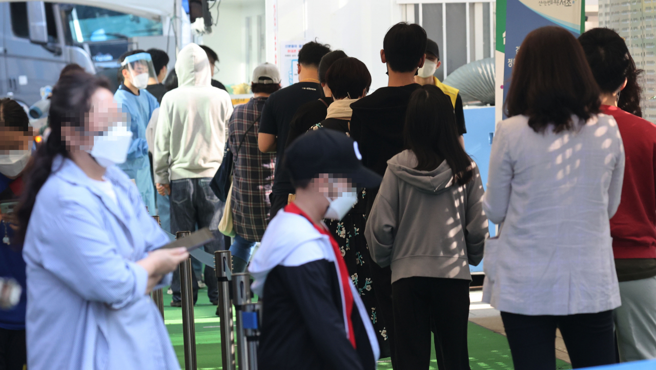 24일 오전 서울 강남역에 마련된 서초구 임시선별진료소에서 시민들이 코로나19 검사를 받기 위해 줄지어 서있다.[연합]