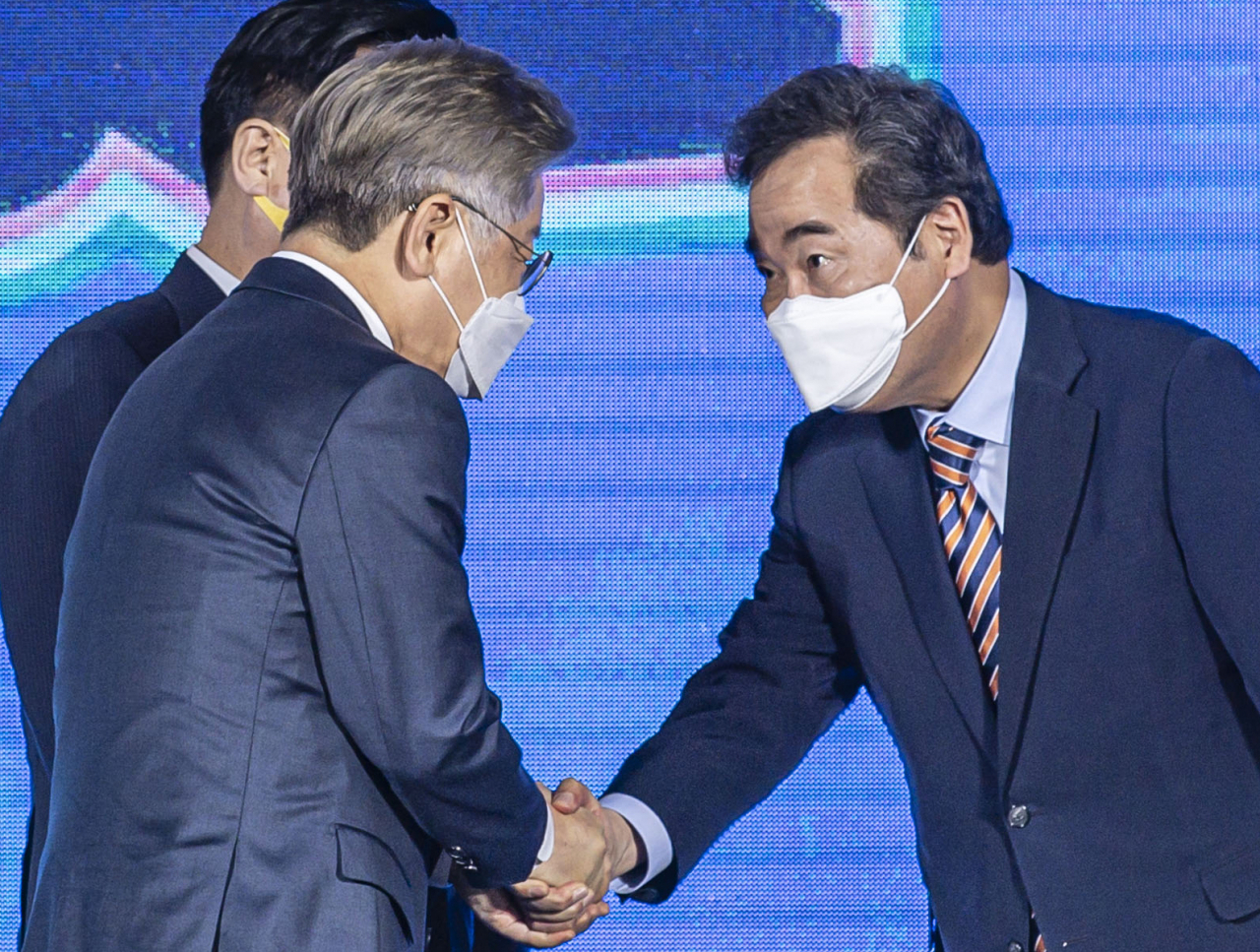 더불어민주당 대통령선거 후보자 선출을 위한 광주·전남 합동연설회가 열린 25일 오후 광주 서구 김대중컨벤션센터 1층 다목적홀에서 경선 득표 결과 발표 직후 이낙연(오른쪽) 후보가 이재명 후보와 악수하고 있다. 이날 광주·전남 경선에서는 이낙연 후보가 47.12%를 득표해 이재명 후보를 근소한 차이로 앞선 1위를 차지했다. [연합]