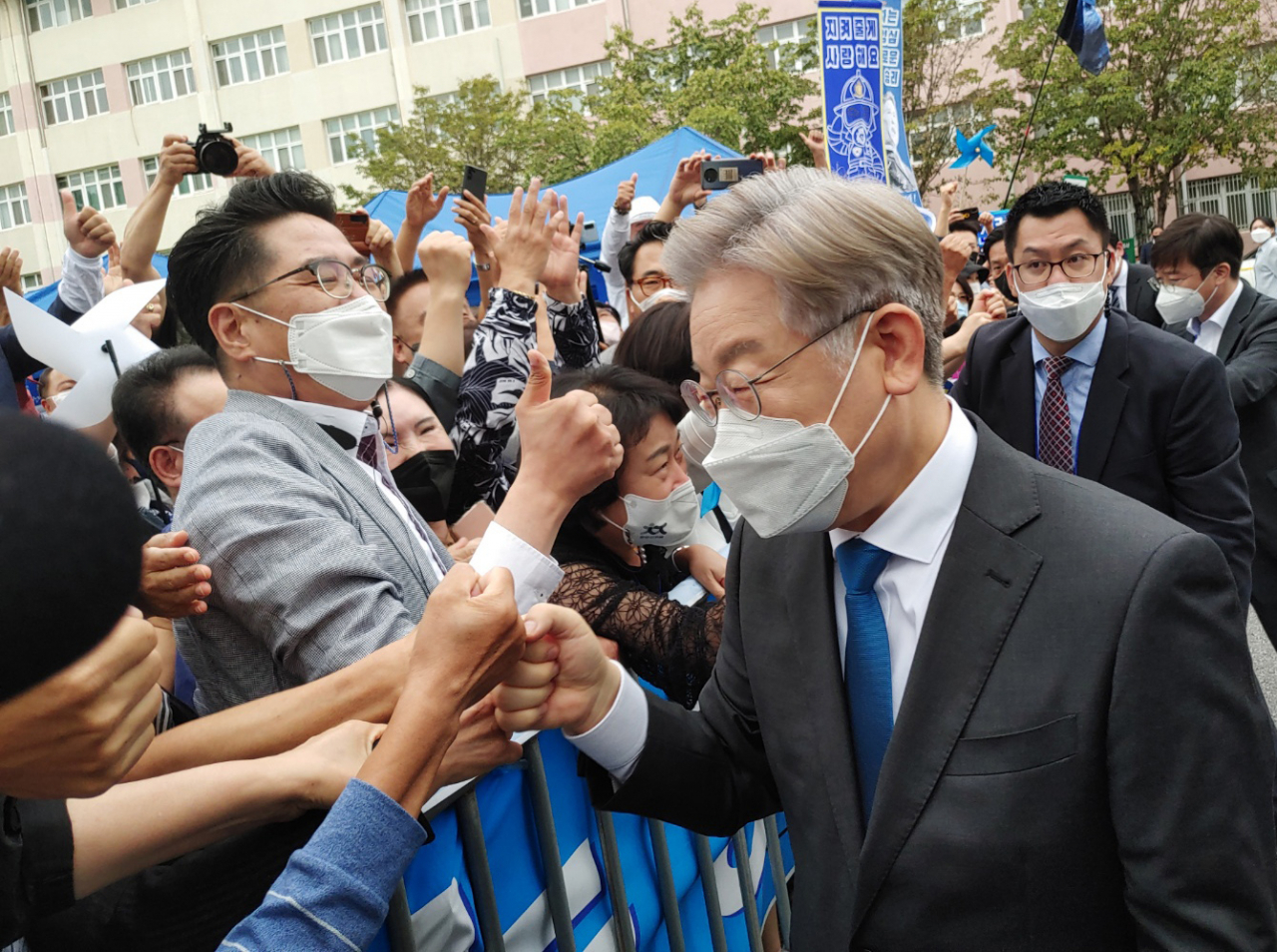 더불어민주당 대선주자인 이재명 경기지사가 26일 전북 완주군 우석대학교 체육관에서 열린 더불어민주당 대선 후보 선출을 위한 전북 합동연설회를 찾은 지지자들과 주먹 인사하고 있다. [연합]