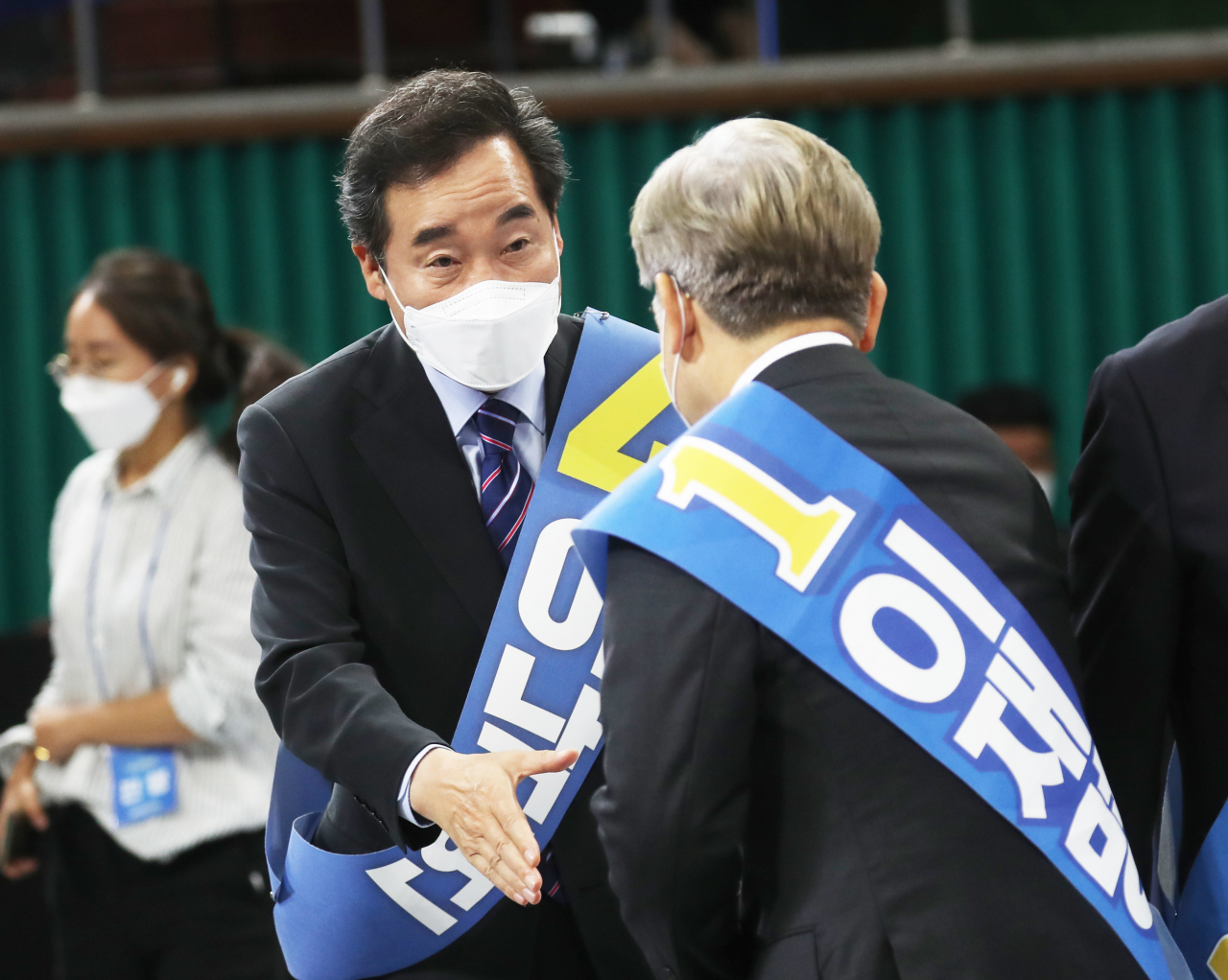 지난 26일 전북 완주군 우석대학교 체육관에서 열린 더불어민주당 대선 후보 선출을 위한 전북 합동연설회에서 이낙연 후보와 이재명 후보가 악수하고 있다. [연합]