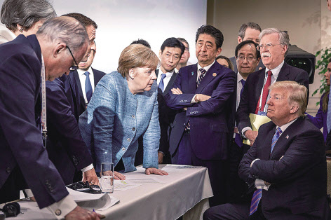 2018년 G7정상회의에서 앙겔라 메르켈(왼쪽 다섯번째) 총리가 의자에 앉아 있는 도널드 트럼프(오른쪽 첫 번째) 대통령을 응시하고 있는 모습. 이 사진으로 메르켈 총리는 트럼프 대통령의 ‘고립주의·국수주의’에 맞서 ‘다자주의’를 지키려는 서방세계 지도자로서의 이미지를 굳혔다. [AFP]