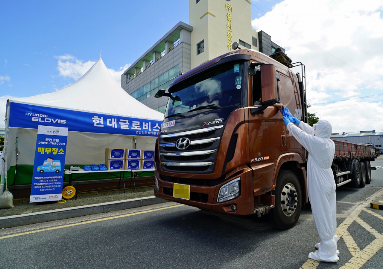 현대글로비스 관계자가 지난 27일 울산화물터미널을 이용하는 화물차 운전자에게 안전용품세트를 전달하고 있다. [현대글로비스 제공]