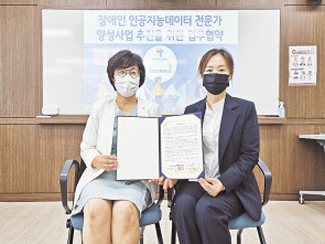 한국장애인고용공단 부산지역 총괄 이효성(왼쪽) 센터장과 테스트웍스 노정화 이사가 협약서를 들어보이고 있다. [테스트웍스 제공]