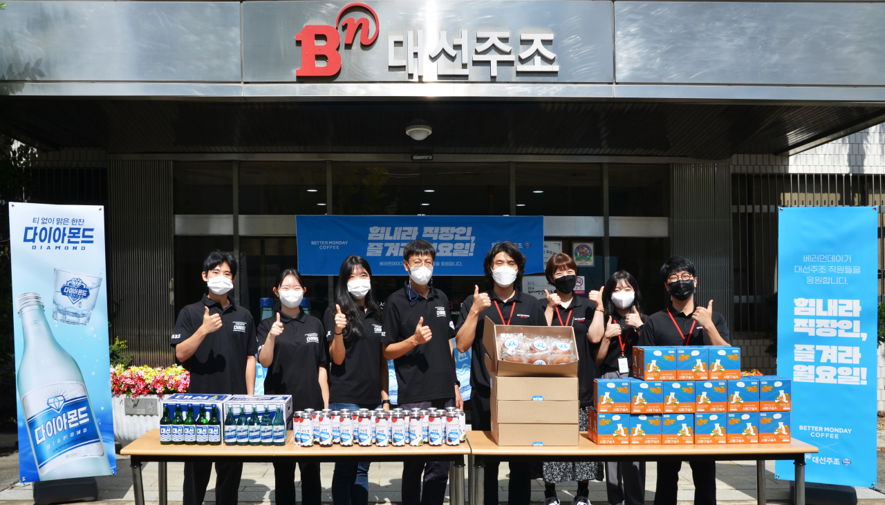 27일 대선주조 본사 입구에서 대선주조와 베러먼데이 임직원들이 음료와 간식 전달 이벤트 기념 사진을 찍고 있다. [대선주조 제공]