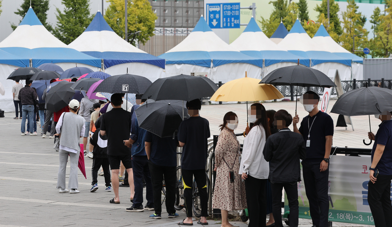 28일 오전 서울 송파구 올림픽공원 앞에 설치된 임시선별검사소에서 시민들이 코로나19 검사를 받기 위해 대기하고 있다. 연합뉴스